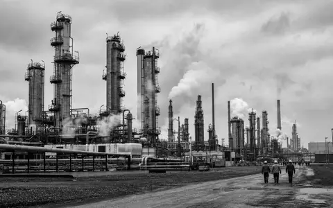 Schwarzweiß-Reportagefoto einer Raffinerie dokumentiert die Ölindustrie von Eni S.p.A. mit ISIN IT0003132476 eindrucksvoll - Foto: THN