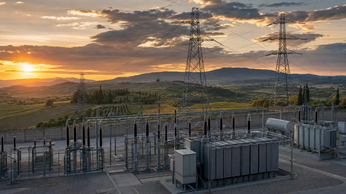 Umspannwerk mit Hochspannungsmasten bei Sonnenuntergang in italienischer Landschaft