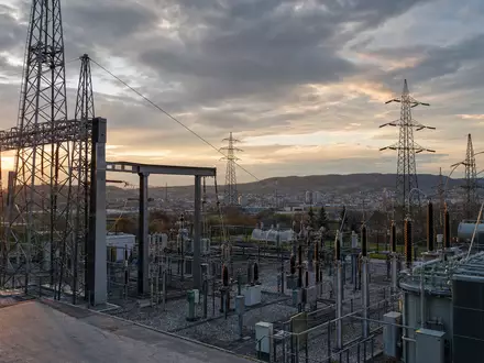 Fotorealistisches Umspannwerk bei Sonnenuntergang zeigt E.ON SE DE000ENAG999 typische Stromnetz-Infrastruktur mit Hochspannungsmasten und Transformatoren - Foto: THN