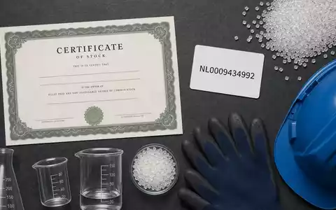 Flatlay mit Aktienzertifikat, ISIN-Karte NL0009434992 und Chemieutensilien symbolisiert eine Geldanlage in LyondellBasell übersichtlich arrangiert - Foto: THN