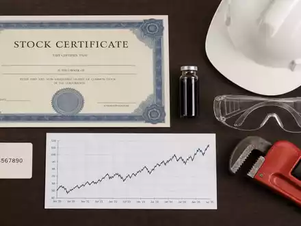 Marathon Petroleum US56585A1025 als Flatlay mit Aktienzertifikat, ISIN-Karte, Schutzhelm und weiteren Raffinerie-Utensilien - Foto: THN