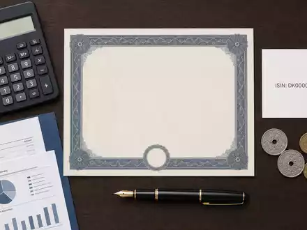 Flatlay-Arrangement mit Aktienzertifikat, ISIN-Karte und Finanzutensilien, symbolisch für Danske Bank A/S, ISIN DK0010274414, Investment - Foto: THN