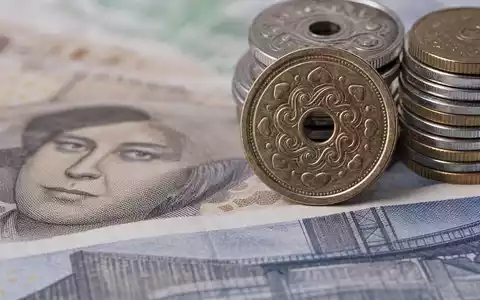 Jyske Bank A/S (DK0010307958) im Makrofoto dänischer Kronen-Münzen und Banknoten mit feiner Detailtextur - Foto: THN