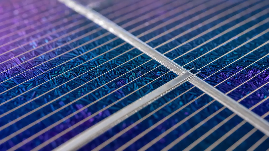 Makroaufnahme einer Solarzelle mit irisierender Kristallstruktur und Silberbusbars