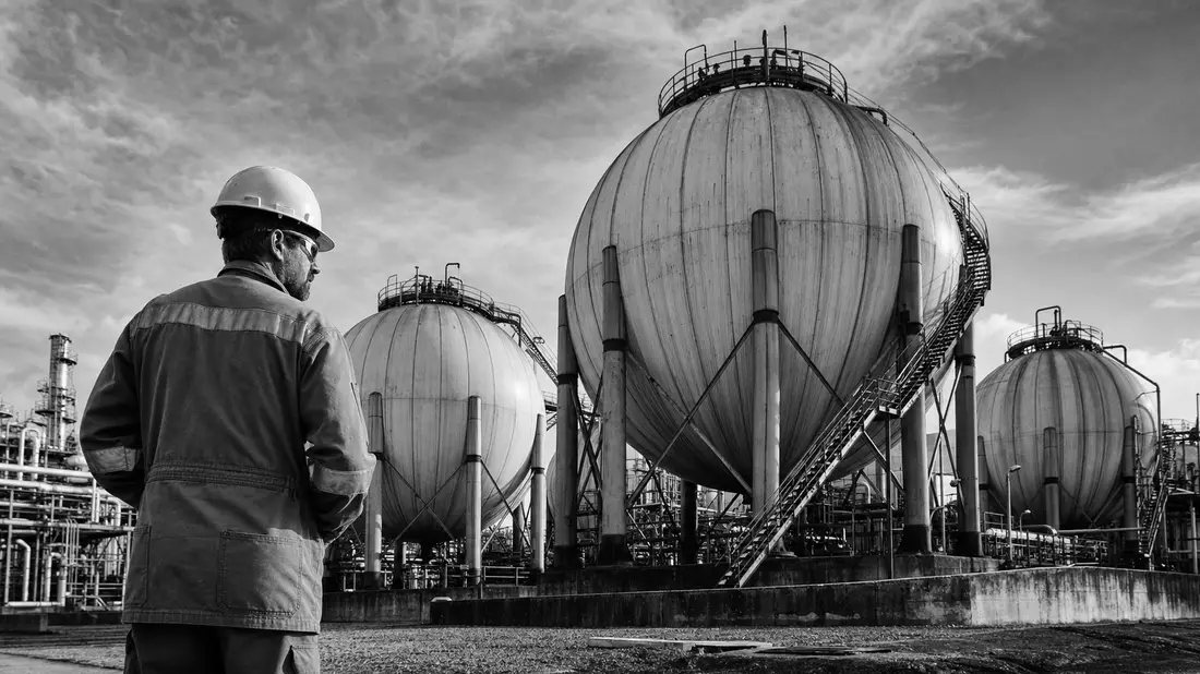 SW-Reportagefoto: Techniker vor riesigen Kugel-Gasspeichern einer Industrieanlage