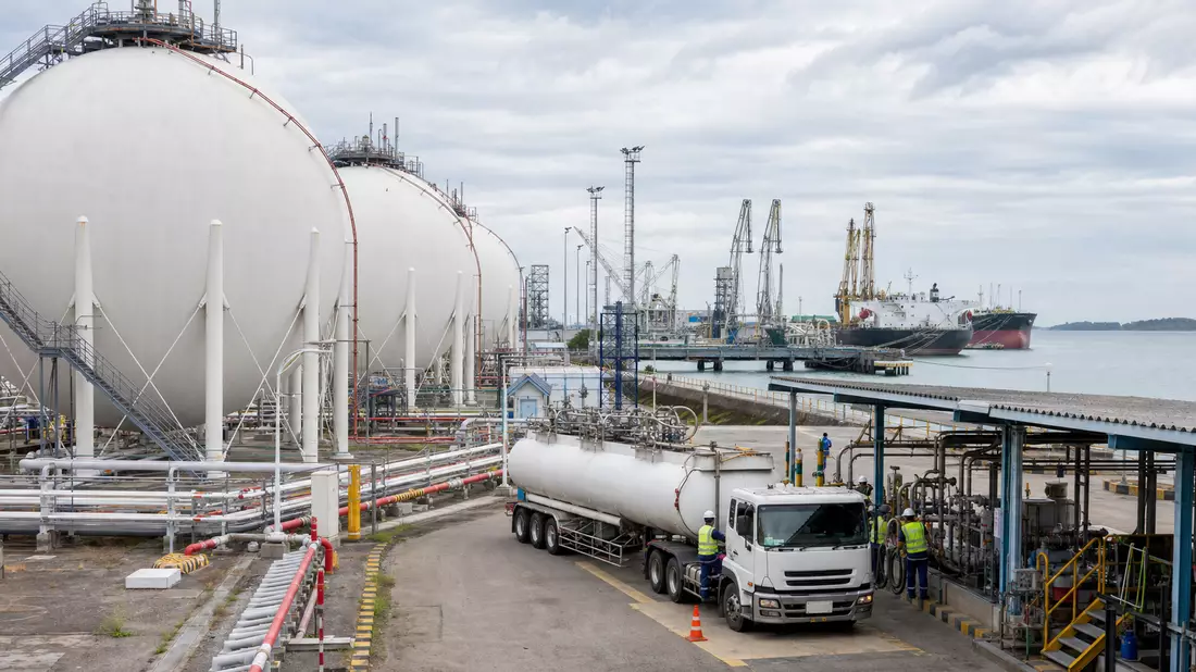 LPG-Terminal mit Tanklastwagen und Frachtschiff am Hafen, Energiedistribution