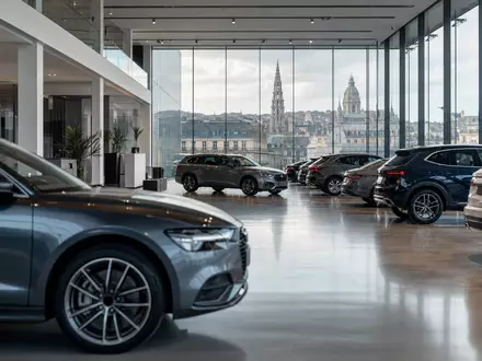 D'Ieteren Group BE0974259880 zeigt fotorealistischen Autohändler-Showroom mit unmarkierten Fahrzeugen und Brüsseler Stadtblick im Hintergrund - Foto: THN