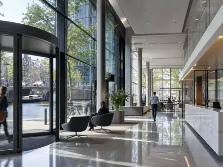 ABN AMRO Bank N.V. mit ISIN NL0011540547 zeigt eine moderne Bankfiliale mit Glasfassade in Amsterdam - Foto: THN