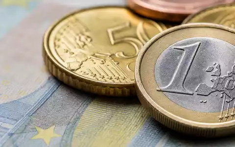 ABN AMRO Bank N.V., ISIN NL0011540547, zeigt eine Makroaufnahme von Euro-Münzen und Banknotenstruktur - Foto: THN