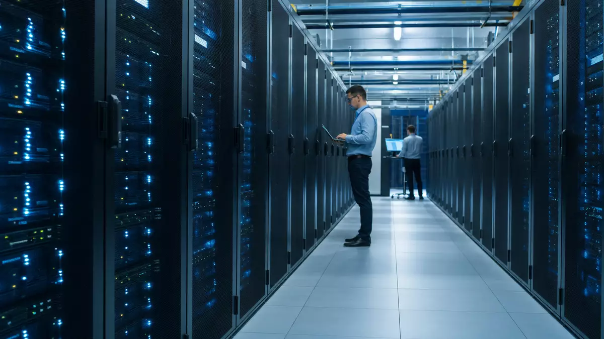 Rechenzentrum mit Serverreihen und Technikern, Motiv zu Tietoevry Oyj IT-Infrastruktur