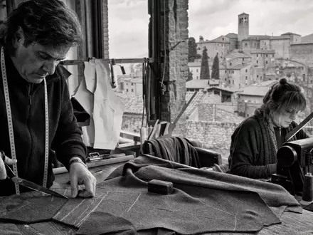 Schwarzweiße Reportagefotografie einer Schneiderei repräsentiert Brunello Cucinelli S.p.A., börsennotiert unter ISIN IT0004764699, dokumentarischer Stil - Foto: THN