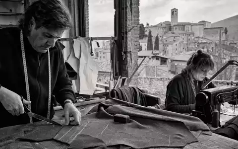 SchwarzweiĂe Reportagefotografie einer Schneiderei reprĂ€sentiert Brunello Cucinelli S.p.A., börsennotiert unter ISIN IT0004764699, dokumentarischer Stil - Foto: THN