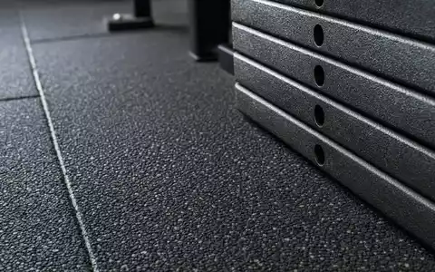 Makroaufnahme von Gummiboden und Gewichtsplatten zeigt Materialien der Fitnessbranche von Technogym S.p.A., ISIN IT0005162406 - Foto: THN