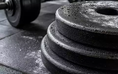 Makroaufnahme von Hantelscheiben und Gummiboden zeigt Detailmaterial der Fitnessbranche von Basic-Fit N.V., ISIN NL0011872650 - Foto: THN