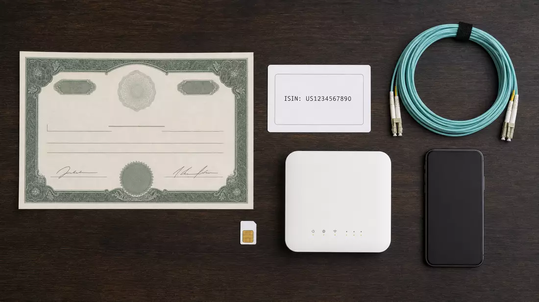 Flatlay-Anordnung aus Aktienzertifikat, ISIN-Karte, Glasfaserkabel und Router auf Holztisch