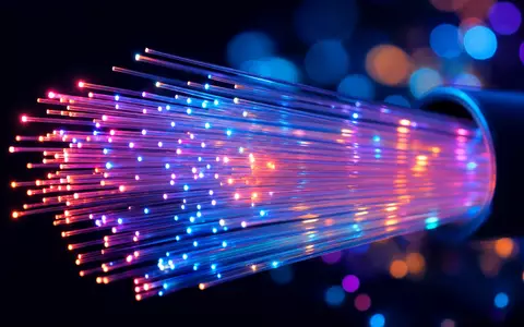 Makroaufnahme leuchtender Glasfaserstränge zeigt die technische Infrastruktur hinter Proximus PLC BE0003810273 Netzwerken - Foto: THN