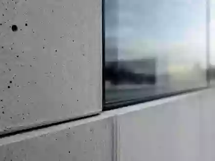 Patrizia SE (DE000PAT1AG3) Makroaufnahme einer Fassaden-Materialstudie aus Beton und Glas mit Texturdetails - Foto: THN