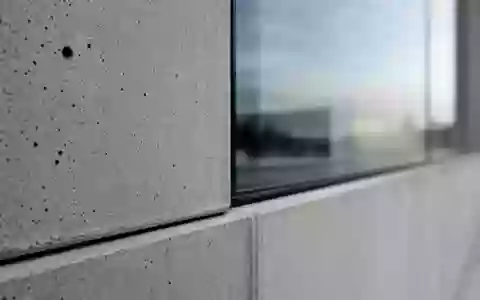 Patrizia SE (DE000PAT1AG3) Makroaufnahme einer Fassaden-Materialstudie aus Beton und Glas mit Texturdetails - Foto: THN