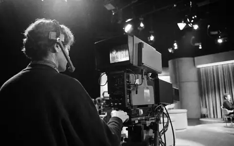 Paramount Global (US92556V1061) Kameramann im generischen TV-Studio, Schwarz-WeiĂ-Reportagestil zeigt authentische Medienbranche eindrucksvoll - Foto: THN