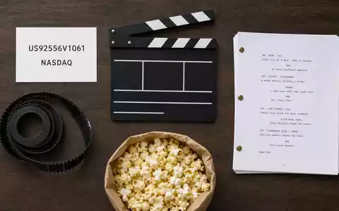 Paramount Global (US92556V1061) Flatlay mit ISIN-Karte, Filmklappe, Filmrolle, Skript und Popcorn-Tüte arrangiert - Foto: THN