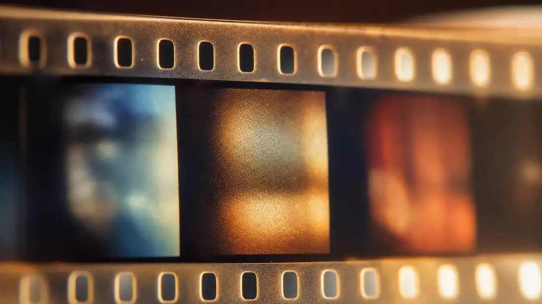 Extreme Nahaufnahme eines analogen Filmstreifens mit sichtbaren Perforationslöchern und Frames