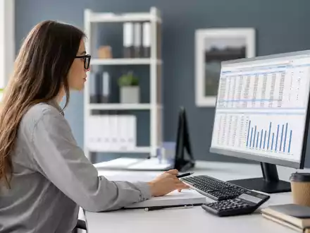 Paychex Inc. US7043261079 zeigt Fotorealismus mit Payroll-Sachbearbeiterin am Bildschirm mit generischen Zahlen im Büro - Foto: THN
