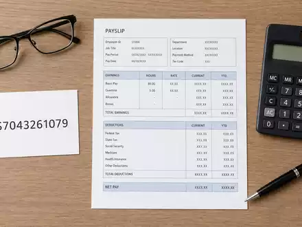 Paychex Inc. US7043261079 als Flatlay mit ISIN-Karte, generischer Gehaltsabrechnung, Taschenrechner und Kugelschreiber - Foto: THN