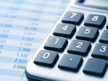 Paychex Inc. US7043261079 in Makroaufnahme eines Taschenrechner-Ziffernblocks vor unscharfer generischer Tabellenkalkulation im Hintergrund - Foto: THN