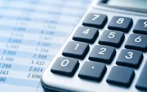 Paychex Inc. US7043261079 in Makroaufnahme eines Taschenrechner-Ziffernblocks vor unscharfer generischer Tabellenkalkulation im Hintergrund - Foto: THN