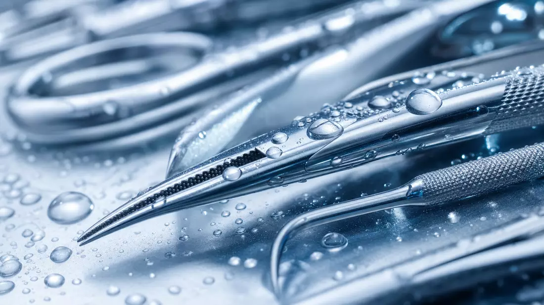 Makroaufnahme glänzender chirurgischer Edelstahlinstrumente mit feinen Sterilisations-Wassertropfen