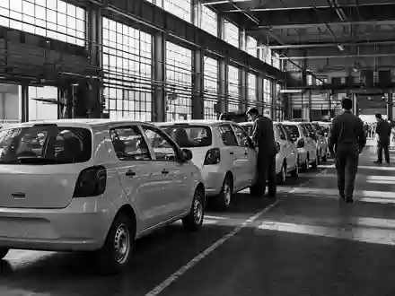 Stellantis N.V. (NL00150001Q9) dokumentiert in Schwarzweiß-Reportage eine Fabrikhalle mit unmarkierten Kleinwagen in Reihen - Foto: THN