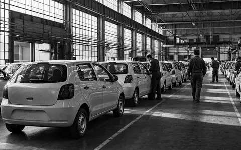 Stellantis N.V. (NL00150001Q9) dokumentiert in Schwarzweiß-Reportage eine Fabrikhalle mit unmarkierten Kleinwagen in Reihen - Foto: THN