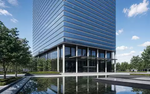 State Street Corp. (US8574771031) präsentiert modernen gläsernen Hochhaus-Neubau mit Wasserbecken und Bäumen tagsüber - Foto: THN