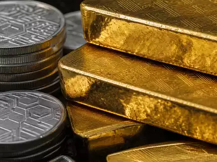 State Street Corp. (US8574771031) fokussiert Makroaufnahme von Goldbarren und Silbermünzen mit dramatischem Licht - Foto: THN