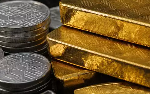 State Street Corp. (US8574771031) fokussiert Makroaufnahme von Goldbarren und Silbermünzen mit dramatischem Licht - Foto: THN