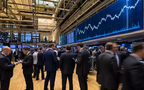 State Street Corp. (US8574771031) begleitet Editorial-Szene vom NYSE-Handelsparkett mit Kursdiagrammen im Hintergrund - Foto: THN