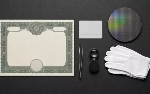 SÜSS MicroTec SE DE000A1K0235 Flatlay zeigt Aktienzertifikat ISIN-Karte Silizium-Wafer Lupe und Reinraum-Handschuhe sorgfältig arrangiert - Foto: THN