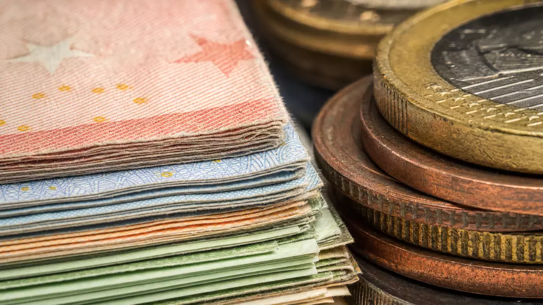 Makrofoto von gestapelten Euro-Banknoten und Münzen mit feiner Textur