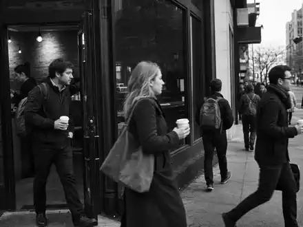 Starbucks Corp. US8552441094 dokumentiert Schwarzweiß-Reportage von Passanten mit Kaffeebechern in belebter Großstadt am Morgen - Foto: THN