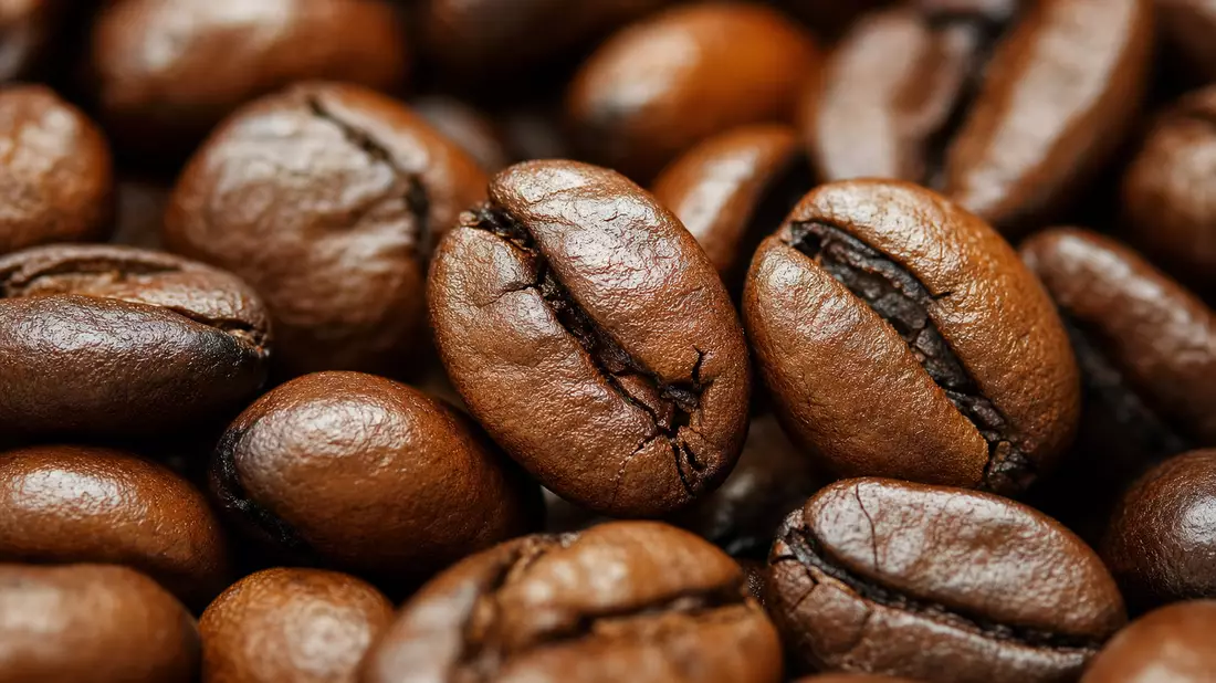 Extreme Makroaufnahme von gerösteten Kaffeebohnen mit sichtbarer Oberflächentextur