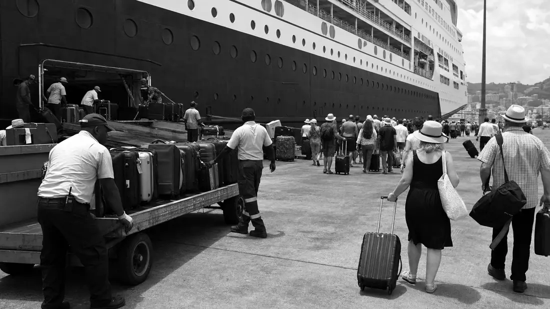 Schwarz-Weiß Dokumentarfoto am Kreuzfahrthafen mit Passagieren und Gepäck