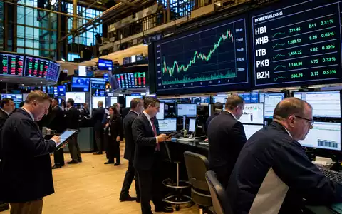 Lennar Corporation (ISIN US5260571048) wird an einem Börsen-Trading-Floor mit Charts des Wohnbausektors dargestellt - Foto: THN