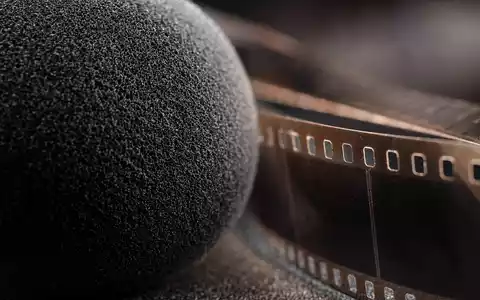 Liberty Media Corp. (US5312298541) zeigt Makroaufnahme von Mikrofonschaumstoff neben einem Streifen altem Filmmaterial - Foto: THN