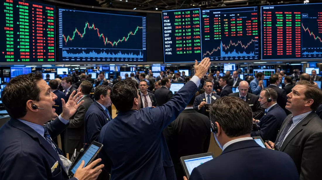 Trading-Floor mit Kurstafeln zu Medien-Sektorkürzeln und gestikulierenden Händlern