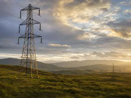 SSE plc (ISIN GB0007908733) betreibt Stromnetze in Schottland mit markanten Freileitungsmasten in Hügellandschaft - Foto: THN
