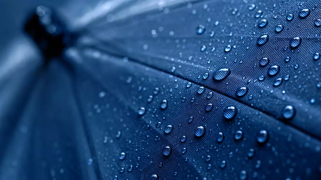 Makro von Wassertropfen auf blauem Regenschirmstoff, Sampo Oyj FI0009003305