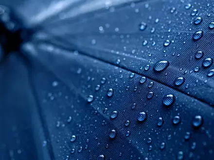 Sampo Oyj (ISIN FI0009003305) steht sinnbildlich für Schutz, dargestellt durch Wassertropfen auf Regenschirmstoff - Foto: THN