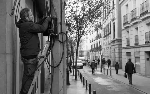 Telefónica S.A. (ISIN ES0178430E18) sichert Netzinfrastruktur, während Techniker Glasfaserkabel in Madrider Straßen installieren und warten - Foto: THN