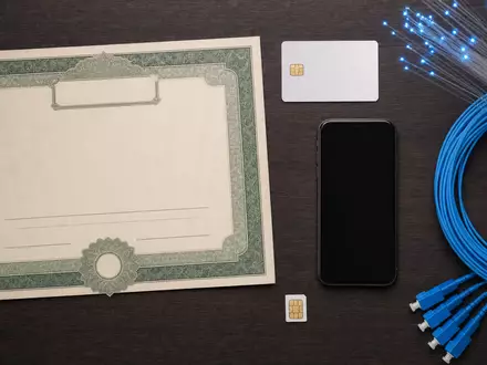 Telefónica S.A. (ISIN ES0178430E18) als Kapitalanlage symbolisiert durch Aktienzertifikat, ISIN-Karte und Telekommunikationszubehör im Flatlay - Foto: THN