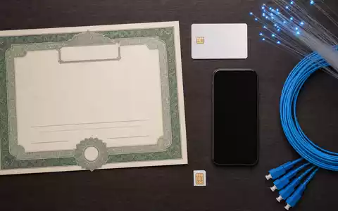 Telefónica S.A. (ISIN ES0178430E18) als Kapitalanlage symbolisiert durch Aktienzertifikat, ISIN-Karte und Telekommunikationszubehör im Flatlay - Foto: THN